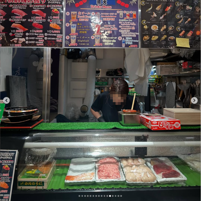 A food counter with ingredients on display beneath illustrated menus.