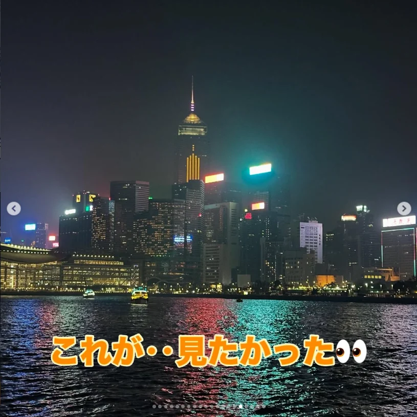 An illuminated waterfront skyline reflected in dark water at night.