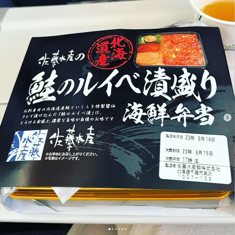A packaged seafood bento with Japanese labelling and a photograph of the meal on the lid.