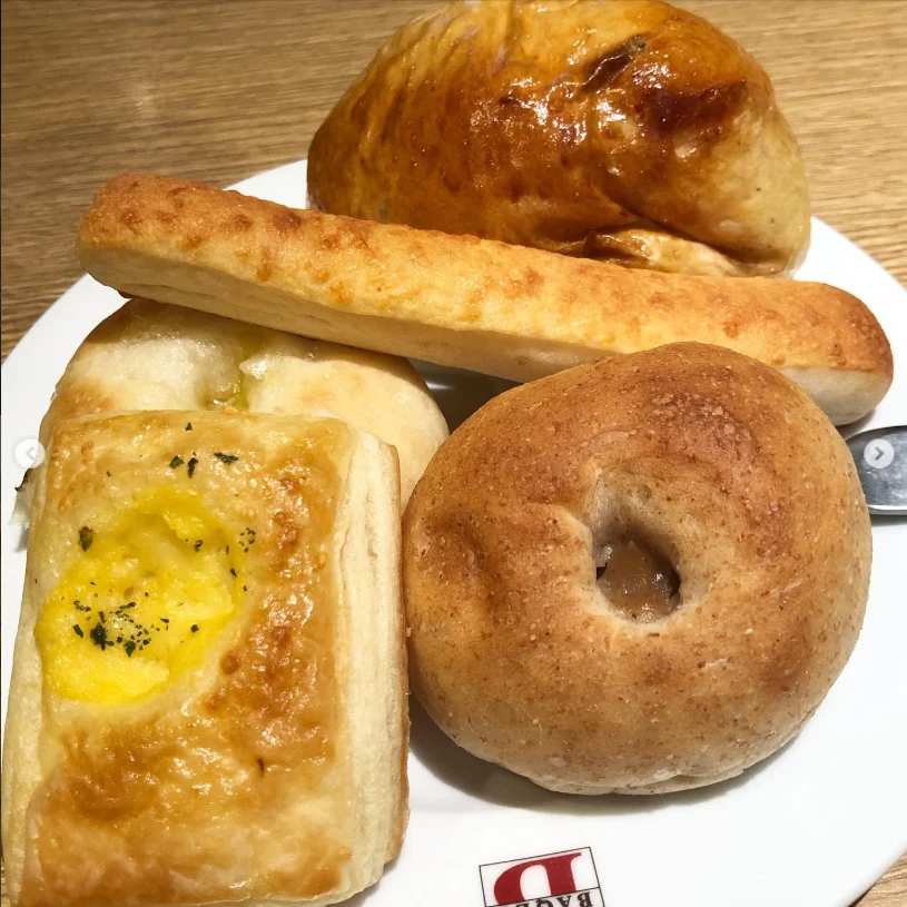 Four differently shaped pieces of bread on a white plate.