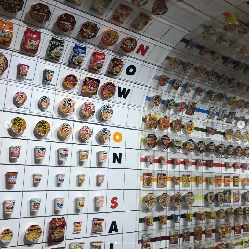 A wall arranged with many small food photographs and large black letters.