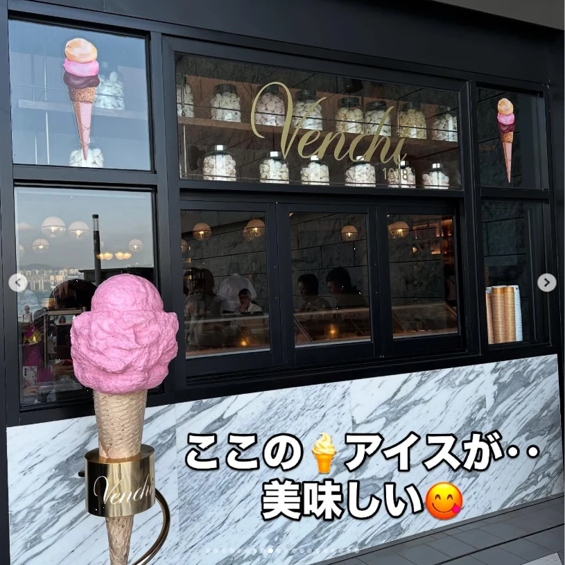 A pink ice-cream cone held in front of a shop window, with Japanese text over the photograph.